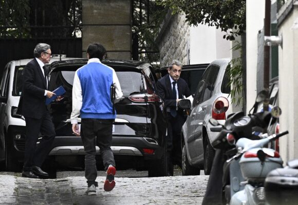 L'ancien président Nicolas Sarkozy (à droite) regagne son domicile, le 13 octobre 2025, accompagné de son avocat Jean-Michel Darrois (à gauche). Il venait d'être reçu par le parquet pour être informé du début de son incarcération. Photo : Julien de Rosa / AFP